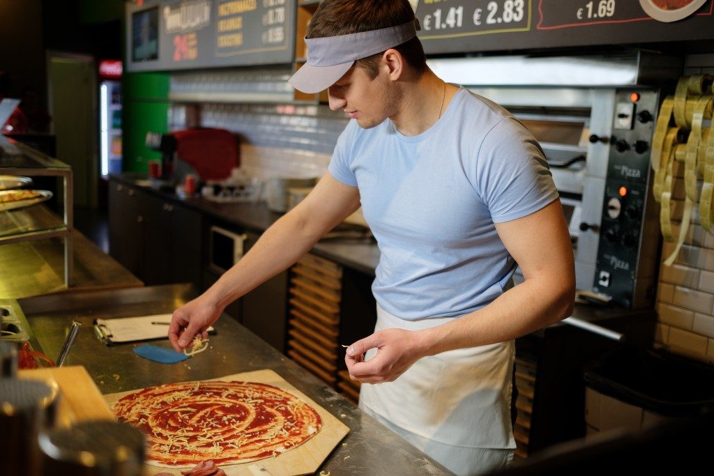 man preparing pizza