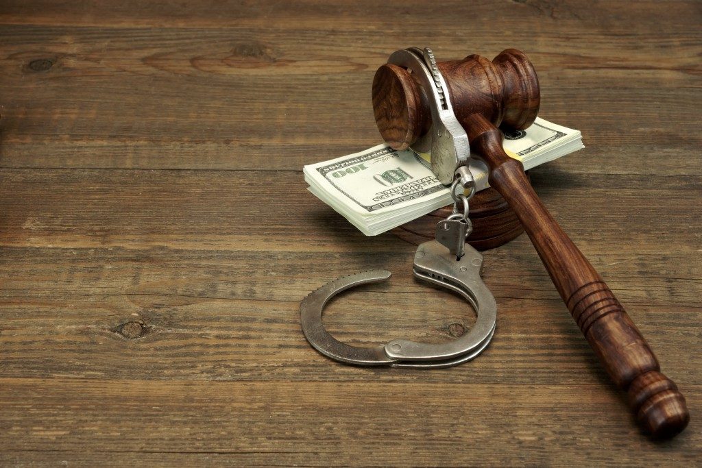 Dollars Cash, Real Handcuffs And Judge Gavel On Rough Wood Background