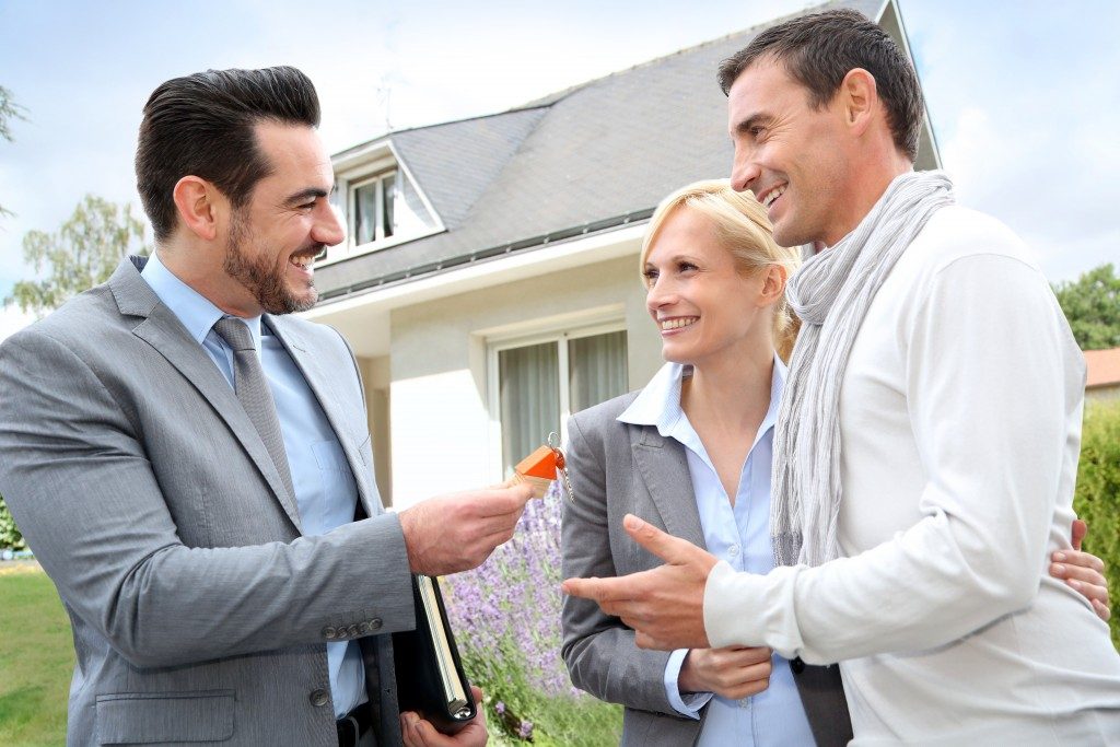 Salesman giving home keys to property owners