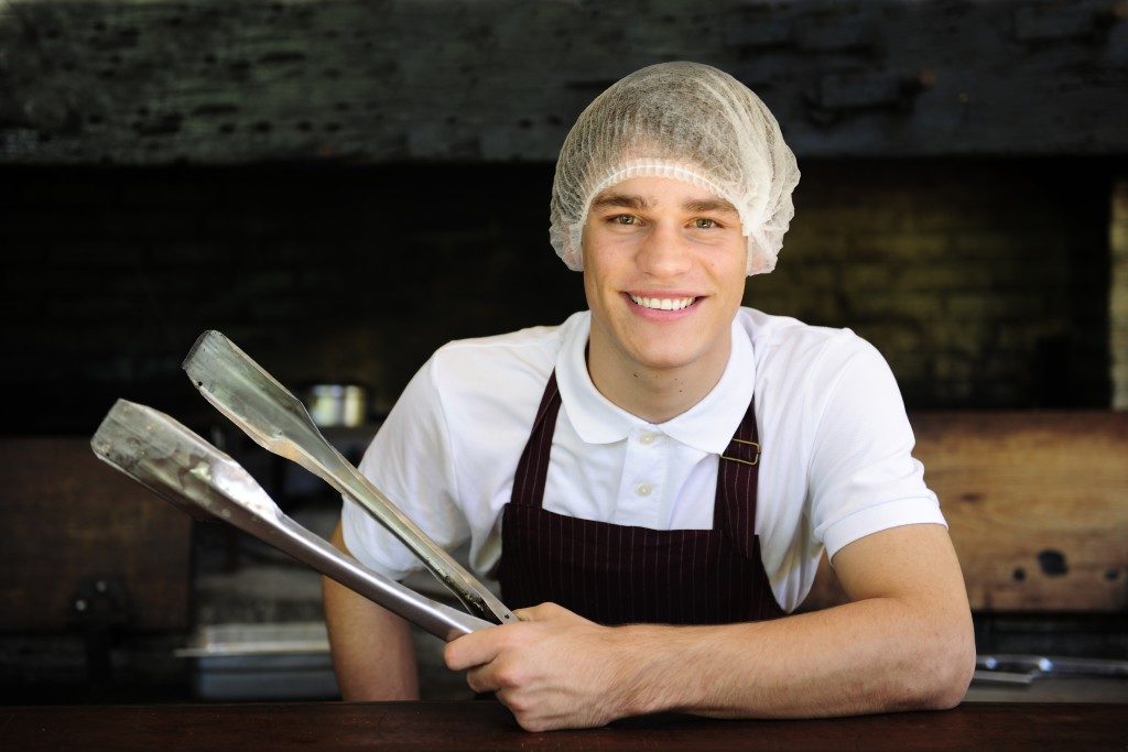 man wearing hair net while cooking