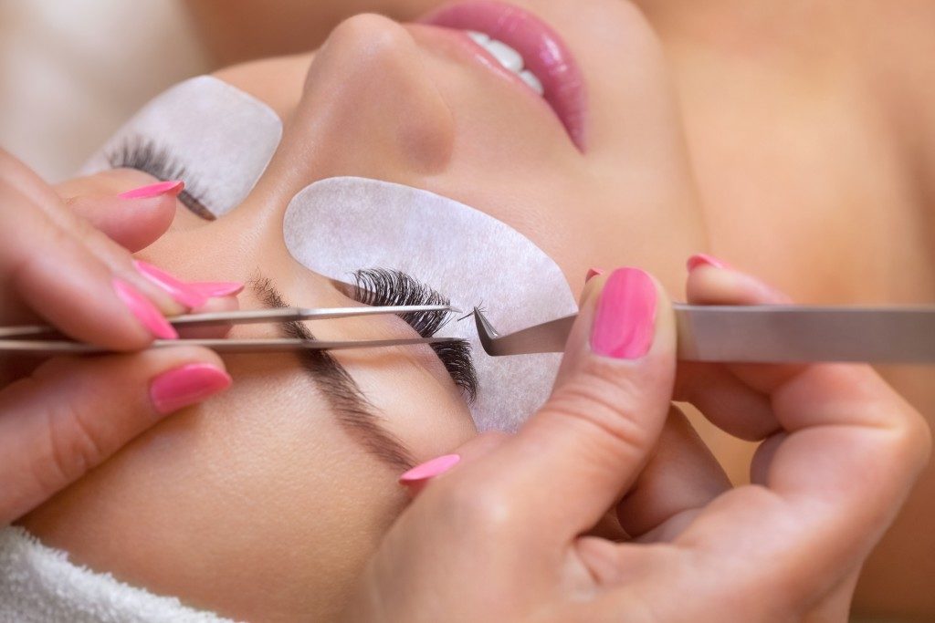 woman undergoing eyelash extension procedure