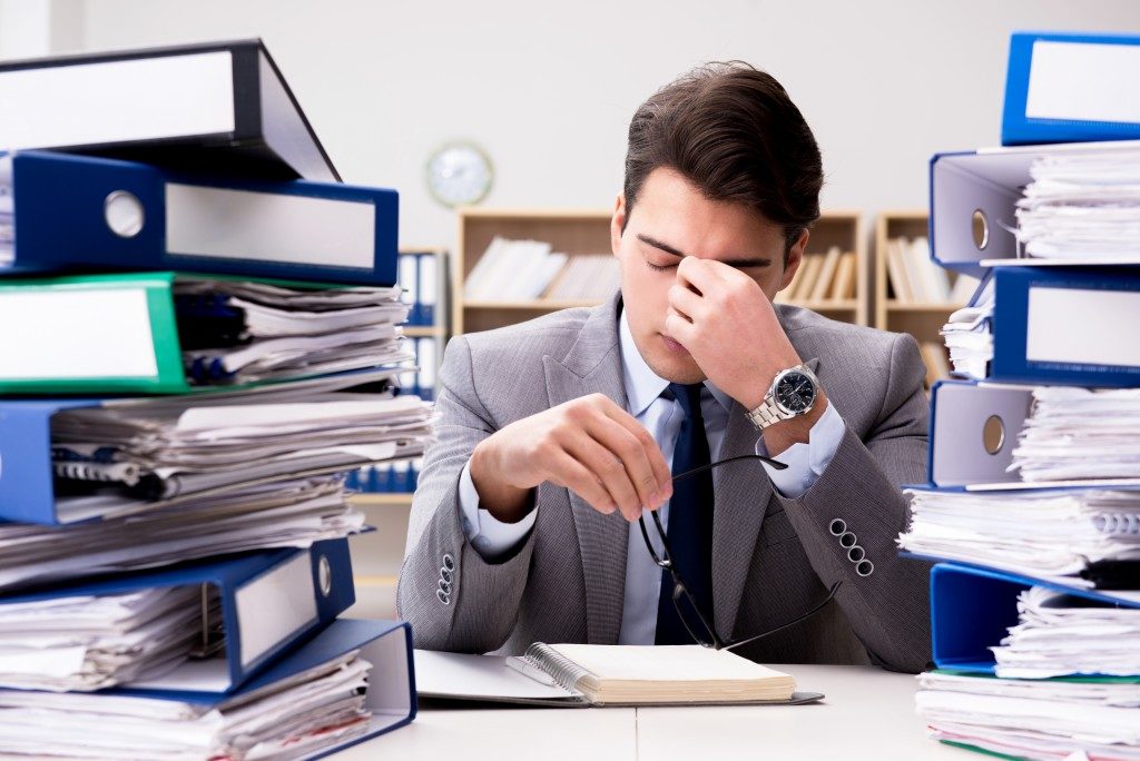 Employee under so much stress, piled up with papers