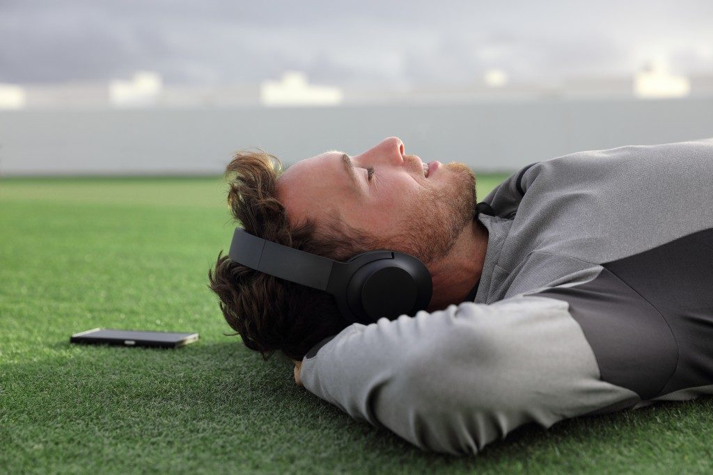 Man lying down on grass with headphones