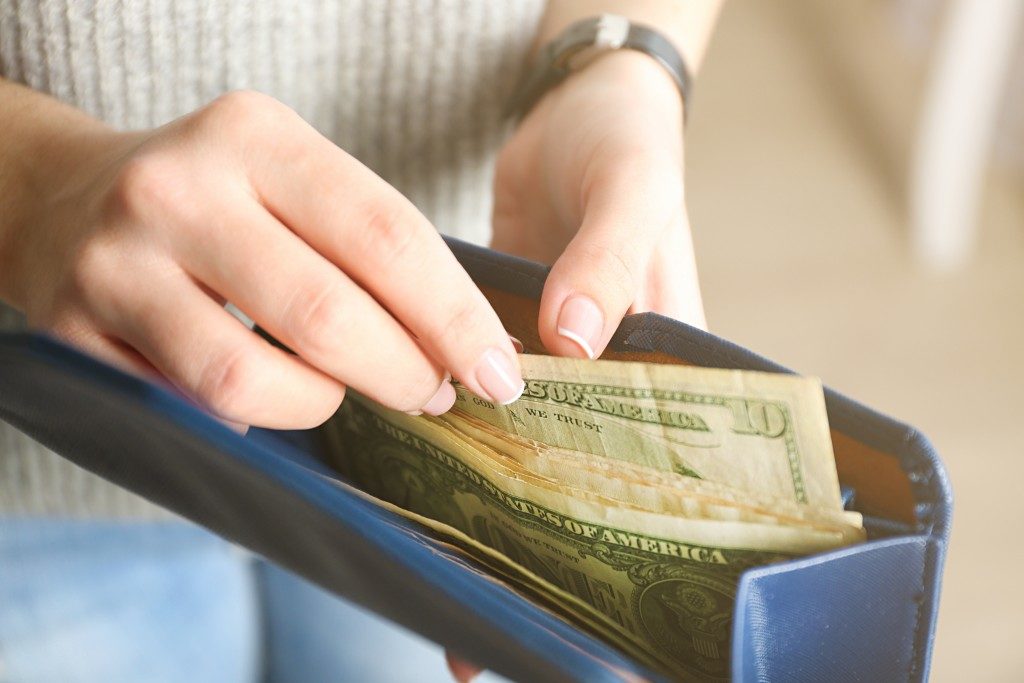 woman pulling cash out of wallet